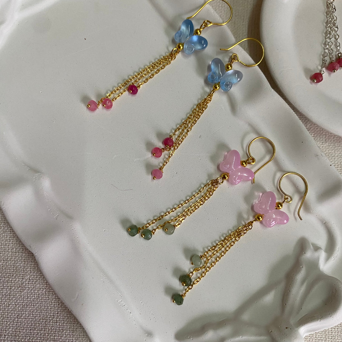 Handmade earrings featuring butterfly charms, cascading chains